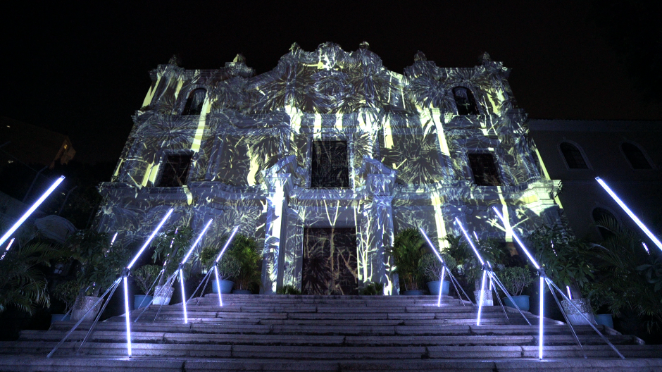 Das japanische Künstlerduo „Flightgraf“ realisiert seit 2013 Fassadenprojektionen (Foto: Kirche St. Joseph in Macau, China). Für das historische Gebäude der Tuchfabrik Müller in Euskirchen entwickeln Kento Tomiyoshi und Makoto Shozu eine Projektion über den globalen Fluss von Ressourcen, Textilien und Bekleidung (19.-26.3.2022). © FLIGHTGRAF / © Foto Syuhei Miyanaga